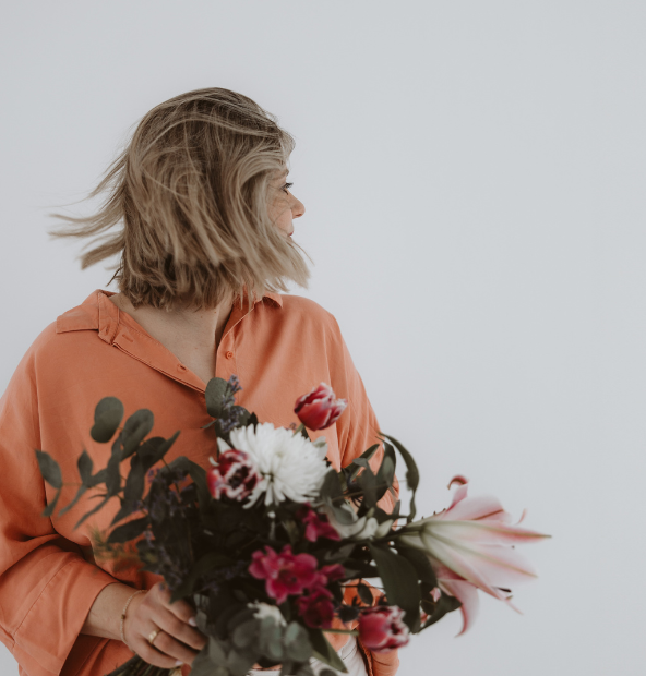 Frau, die mit Blumen in der Hand tanzt